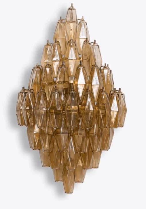 A tiered chandelier with numerous faceted, elongated diamond-shaped glass elements. The glass appears to be amber or smoked colored and is suspended from a metallic frame, likely brass or a similar metal. The arrangement of the glass elements creates a cascading effect. — 3D model