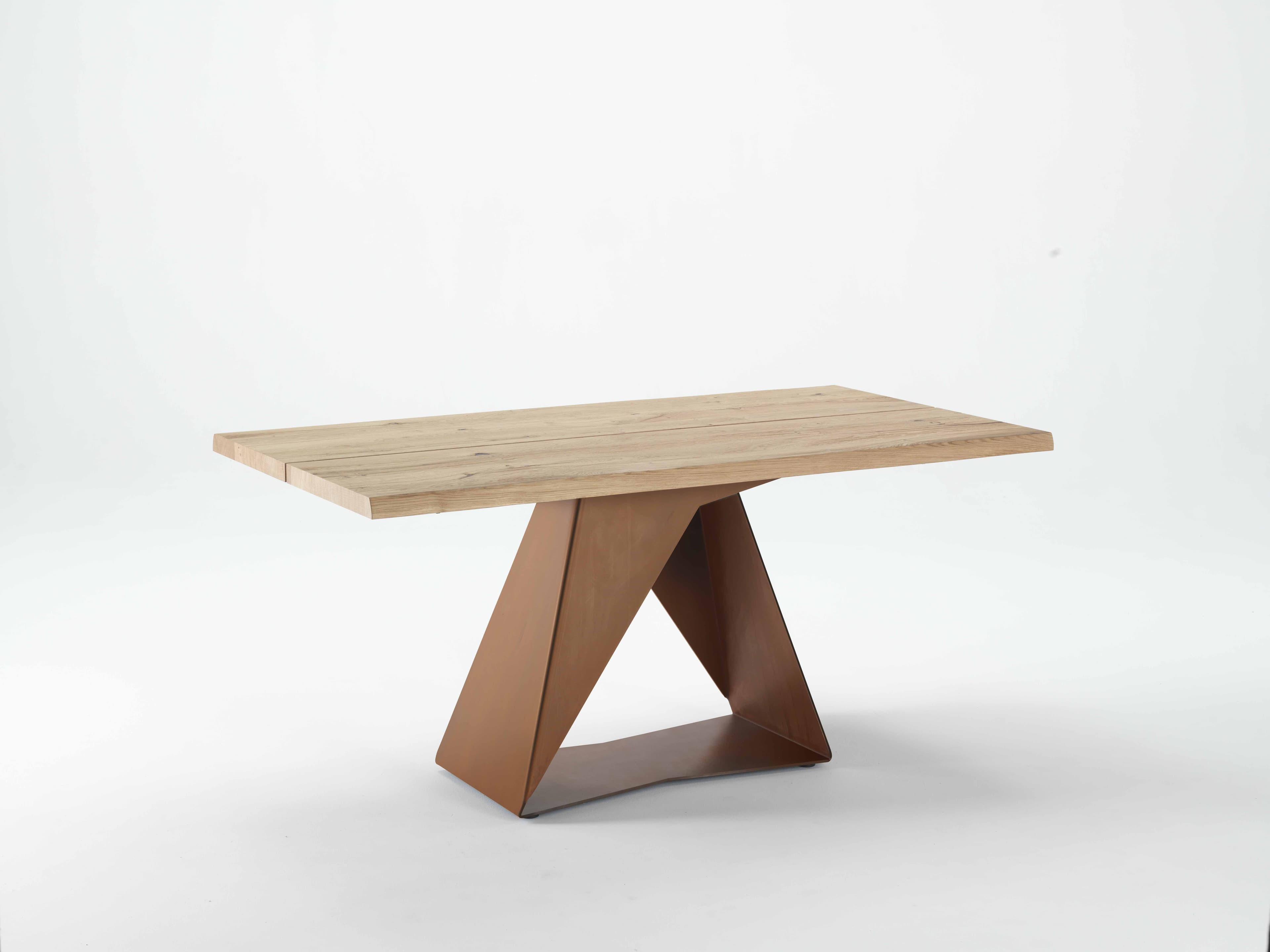 A rectangular dining table with a rustic wooden top and a unique, angular metal base. The tabletop is constructed from planks of light-colored wood, showcasing natural grain and imperfections. The base features geometric, folded metal sections in a warm, rusty brown hue, providing a stark contrast to the natural wood. — 3D model