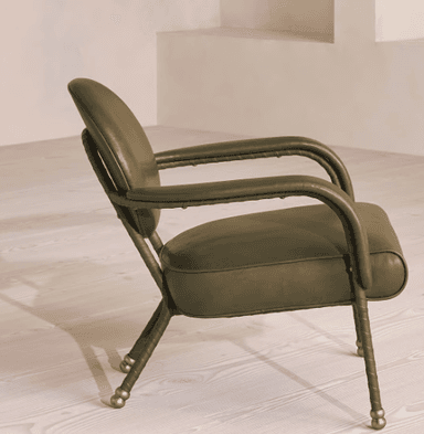A contemporary armchair with a rounded backrest and armrests, upholstered in a muted olive-green material. The frame appears to be made of metal with a dark finish, and the legs are slender with decorative brass caps. — 3D model