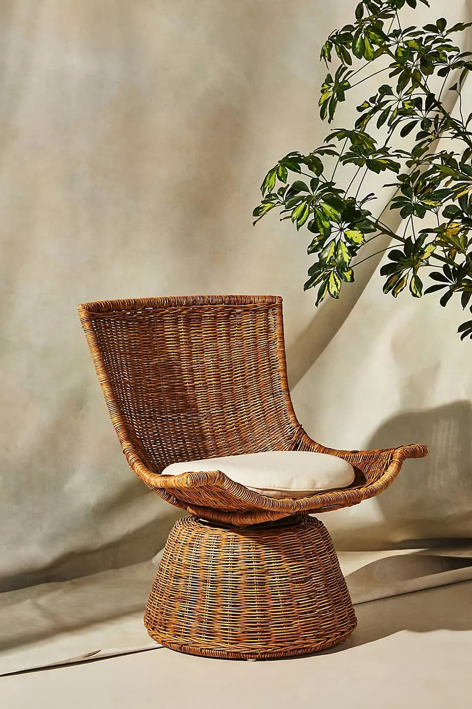 A vintage-style woven rattan swivel chair with a high back and a cylindrical base, featuring a light-colored seat cushion. — 3D model