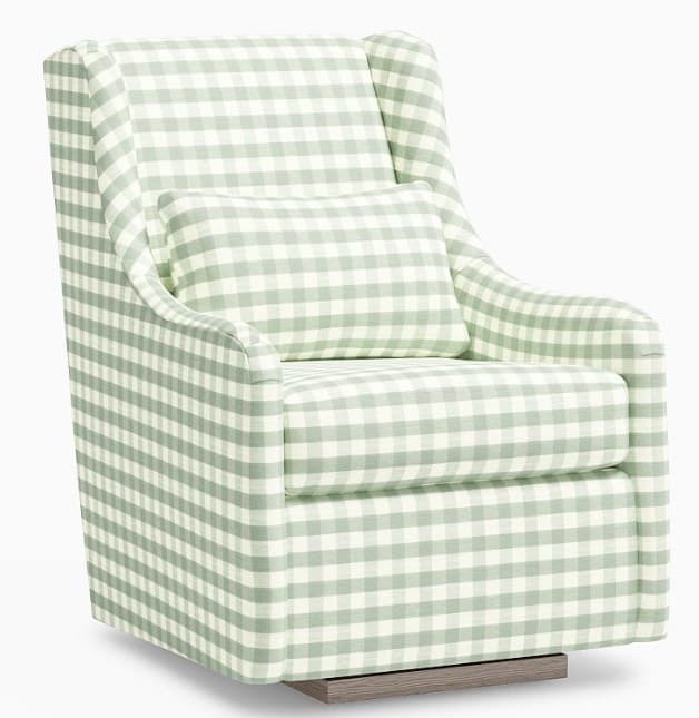 A wingback armchair upholstered in a green and white gingham fabric. It features a high back with winged sides, curved arms, and a removable lumbar pillow. The base appears to be a swiveling wooden platform with a weathered wood finish. — 3D model