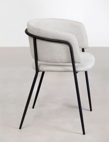 A minimalist dining armchair featuring a slender black metal frame and light grey upholstered seat and backrest. The backrest is gently curved, providing integrated arm support as it wraps around the sides. The seat cushion is separate from the backrest, with a slight gap visible between the two elements. The four tapered metal legs splay slightly outwards, contributing to a modern aesthetic. — 3D model