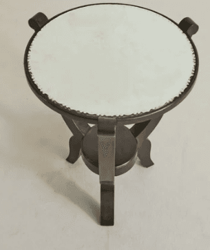 A circular end table with a light-colored, textured top and a dark wooden base. The base features a central circular shelf connected to three distinct legs, each with a curved top support. The legs have a dark, possibly stained or painted finish. — 3D model
