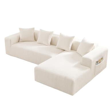 A modern, cream-colored sectional sofa featuring a chaise lounge component and an integrated storage pocket on one armrest. The sofa is upholstered in a textured fabric, likely boucle, providing a soft and inviting appearance. It has a low-profile, modular design with clean lines and includes several loose back cushions of the same material. — 3D model
