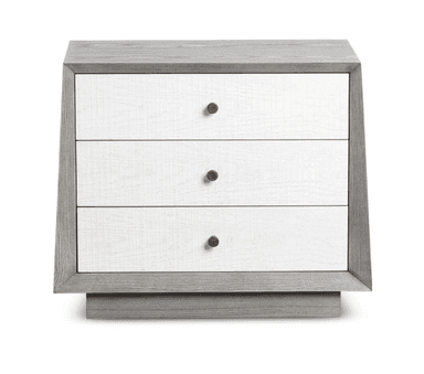 A contemporary nightstand with a distinctive design. It features a grey-toned wooden frame with a weathered texture and a contrasting white front panel. The front is composed of three drawers, each with a small, round, brown knob for a handle. The nightstand is elevated by a solid base with a beveled edge. — 3D model