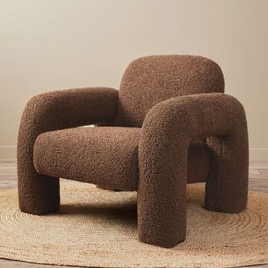 A modern armchair upholstered in a plush, textured teddy fabric. This chair features a rounded, enveloping silhouette with substantial, integrated armrests that flow seamlessly into the back and seat. Its thick cushioning and tactile surface invite comfort and relaxation. The overall design is contemporary, with clean lines and a soft, inviting appearance, supported by a sturdy, low-profile base. — 3D model