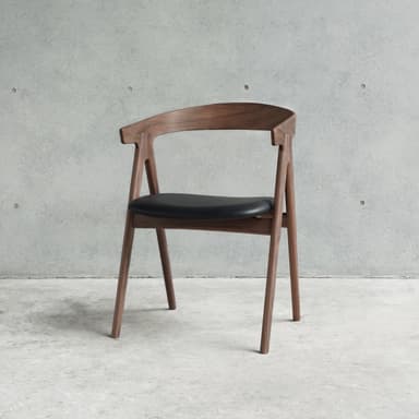 A modern armchair with a curved wooden frame and a black upholstered seat. The chair has four angled legs, a curved backrest that extends into armrests, and a distinctively shaped seat. — 3D model