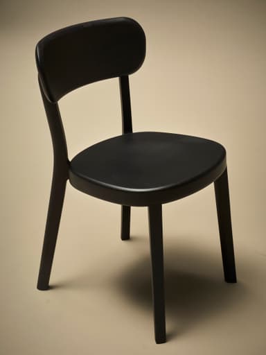 A dark-colored wooden dining chair viewed from the back. The chair features a gently curved backrest supported by two upright posts that extend from the seat. The seat itself is also curved and appears to be solid. The legs are slightly tapered and angled outwards. The overall construction suggests a modern or contemporary design with clean lines and a minimalist aesthetic. — 3D model
