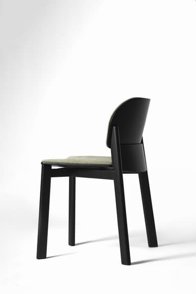 An armless modern dining chair featuring a solid black wooden frame and light green fabric upholstery on both the seat and the curved backrest. The chair is presented in a studio setting against a white background. — 3D model