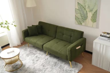 An olive green upholstered sofa bed with a textured boucle fabric, featuring a tufted backrest and golden tapered metal legs. The sofa design suggests convertibility with segmented seat and back cushions. A small green throw pillow and an integrated side pocket are also visible. — 3D model