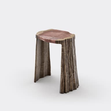 A sculptural accent table featuring an irregular reddish natural stone top, bordered by a thin brass trim. The base is composed of three sturdy legs crafted from what appears to be cast bronze, exhibiting a heavily textured, bark-like finish in a dark, weathered tone. The overall design emphasizes organic forms and robust materials. — 3D model
