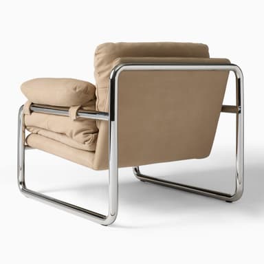 A contemporary armchair featuring a tubular chrome-plated steel frame supporting plush, upholstered cushions. The upholstery has a soft texture, possibly velvet or a similar fabric, in a warm ochre or mustard yellow color. The design is minimalist and iconic, with the metal frame forming a distinctive silhouette. — 3D model
