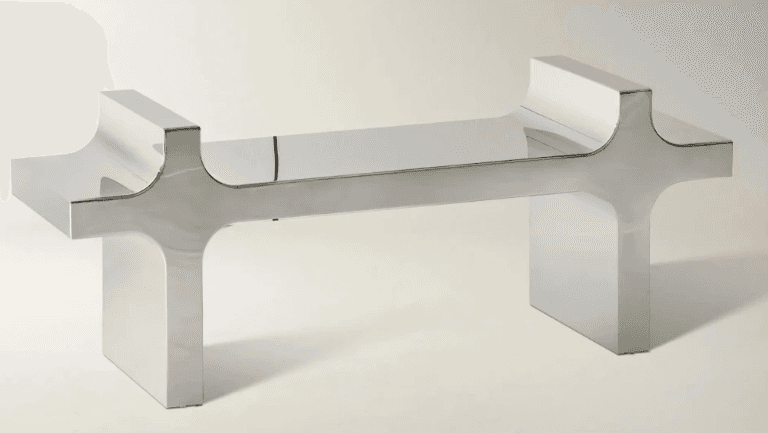 A modern console table with a polished chrome finish. The table features a linear top supported by two stylized, H-shaped pedestal legs. The legs have a broad base and taper slightly upwards, with curved indentations on the inner sides where they meet the tabletop. — 3D model