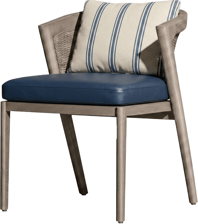 A contemporary armchair featuring a light gray-toned wooden frame with visible grain. The backrest is detailed with a woven cane or rope material. It has integrated armrests and a padded seat upholstered in smooth navy blue leather. The chair stands on four slender, tapered wooden legs. A cream-colored throw pillow with blue vertical stripes is placed on the seat. — 3D model