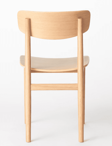 An armless dining chair constructed entirely from light-toned wood, likely oak or ash, with a natural finish. It features a gently curved backrest and a contoured seat, supported by four round, tapered legs reinforced with horizontal stretchers. — 3D model