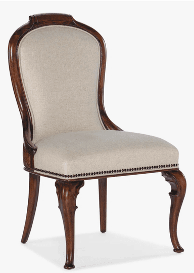 A classic armchair with a carved wooden frame and upholstered seat and back. The upholstery is a light beige linen-like fabric, tufted with decorative nailhead trim along the base of the seat cushion and the perimeter of the backrest. The wooden frame exhibits a dark brown, polished finish. The backrest has a curved, elongated shape, while the front legs feature a cabriole design with scroll details, terminating in a bulbous foot. — 3D model