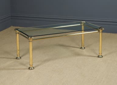 A rectangular coffee table featuring a polished brass tubular frame and a smoked glass top. The design incorporates classical elements such as columnar legs with fluted details and decorative corner finials. — 3D model