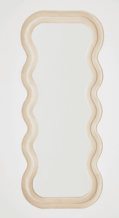 A decorative mirror with a unique, undulating frame. The frame has a soft, plush appearance and follows a continuous, wavy pattern around the reflective surface. The mirror itself is rectangular with rounded corners and a smooth, clear reflective surface. — 3D model