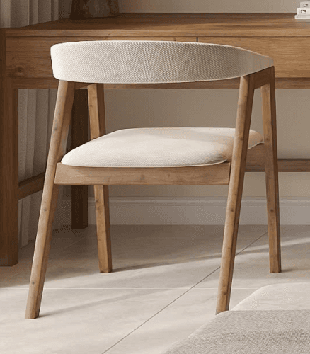 A contemporary armchair featuring a light-toned wooden frame and cream-colored upholstered seat and backrest. The backrest curves seamlessly to form integrated armrests, and the legs are slender and tapered. — 3D model
