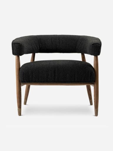 A modern upholstered accent armchair featuring a black bouclé fabric, a solid wooden frame, and tapered legs with brass caps. — 3D model