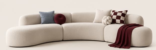 A large, modern modular sectional sofa with a curved form, upholstered in a light, textured boucle fabric. It comprises multiple soft-edged segments, offering a contemporary and inviting seating arrangement. It is accessorized with various decorative pillows and a throw blanket. — 3D model