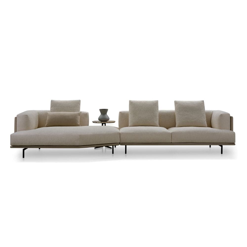 A contemporary modular sectional sofa featuring a chaise lounge section, a two-seater section, and an integrated circular side table. The sofa is upholstered in a textured cream-colored fabric and supported by slender dark metal legs. — 3D model