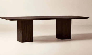 A rectangular dining table crafted from dark wood, featuring a thick, smooth tabletop. The table is supported by two substantial, vertically fluted pedestal bases, providing a modern and minimalist aesthetic. The dark finish enhances its elegant and robust presence. The ends of the tabletop show a subtle rounding. — 3D model