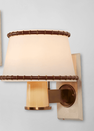 A modern wall sconce featuring a rectangular marble backplate, a short brass arm, and a conical frosted glass shade. The shade is accented with decorative brown leather wrapping, secured with lacing at its top and bottom edges. — 3D model