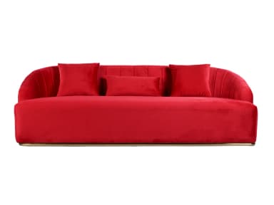 A modern red velvet sofa with a curved back and armrests. The back features vertical channeling, and it comes with three throw pillows: two square and one rectangular. The sofa is elevated by a thin, polished metallic base. — 3D model