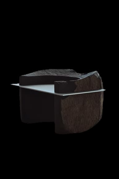 A sculptural bench featuring a dark, rough-hewn stone or concrete structure with a sleek, flat metal or polished stone seat. The design incorporates integrated backrest and armrests, creating a monolithic and artistic form. — 3D model