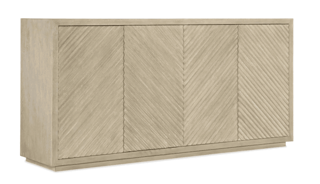 A long, rectangular sideboard with four doors featuring a distinctive textured pattern. The doors have a chevron or herringbone-like carved design, running vertically in sections. The piece rests on a low plinth base. The finish is a light, natural wood tone. — 3D model