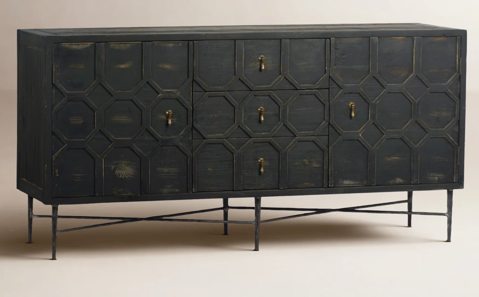 A long, rectangular sideboard with a dark, distressed finish and a geometric overlay pattern on the doors and drawer fronts. It features multiple cabinet doors and drawers, each with brass-colored pull handles. The sideboard is supported by thin, dark metal legs with an intersecting stretcher base. — 3D model