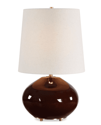 A modern table lamp featuring a bulbous, gourd-shaped ceramic base with a high-gloss dark brown glaze. It is topped with a tapered drum shade made of off-white, textured fabric. The lamp includes gold-toned metal accents visible at the base feet, the neck connecting to the shade, and as a finial. — 3D model