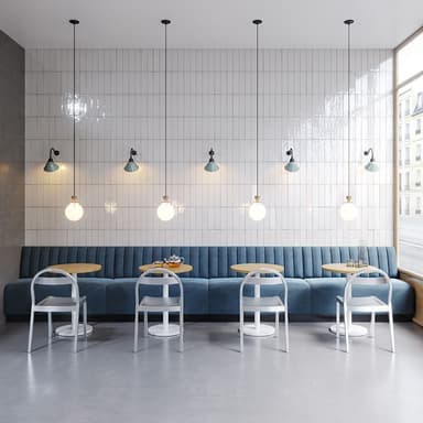 A commercial booth seating arrangement featuring a long, linear bench with a channel-tufted backrest, upholstered in a blue fabric. Accompanying the bench are two round-top tables with light wooden surfaces and white pedestal bases, and two minimalist white chairs with curved backrests and slender legs. — 3D model