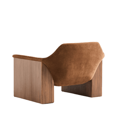 A contemporary armchair with a rounded, upholstered seat and backrest, featuring a detached lumbar cushion. The frame is constructed with solid wood panels that form substantial, block-like legs and armrests. The wood grain is prominently displayed, and the upholstery has a soft, velvety texture. — 3D model