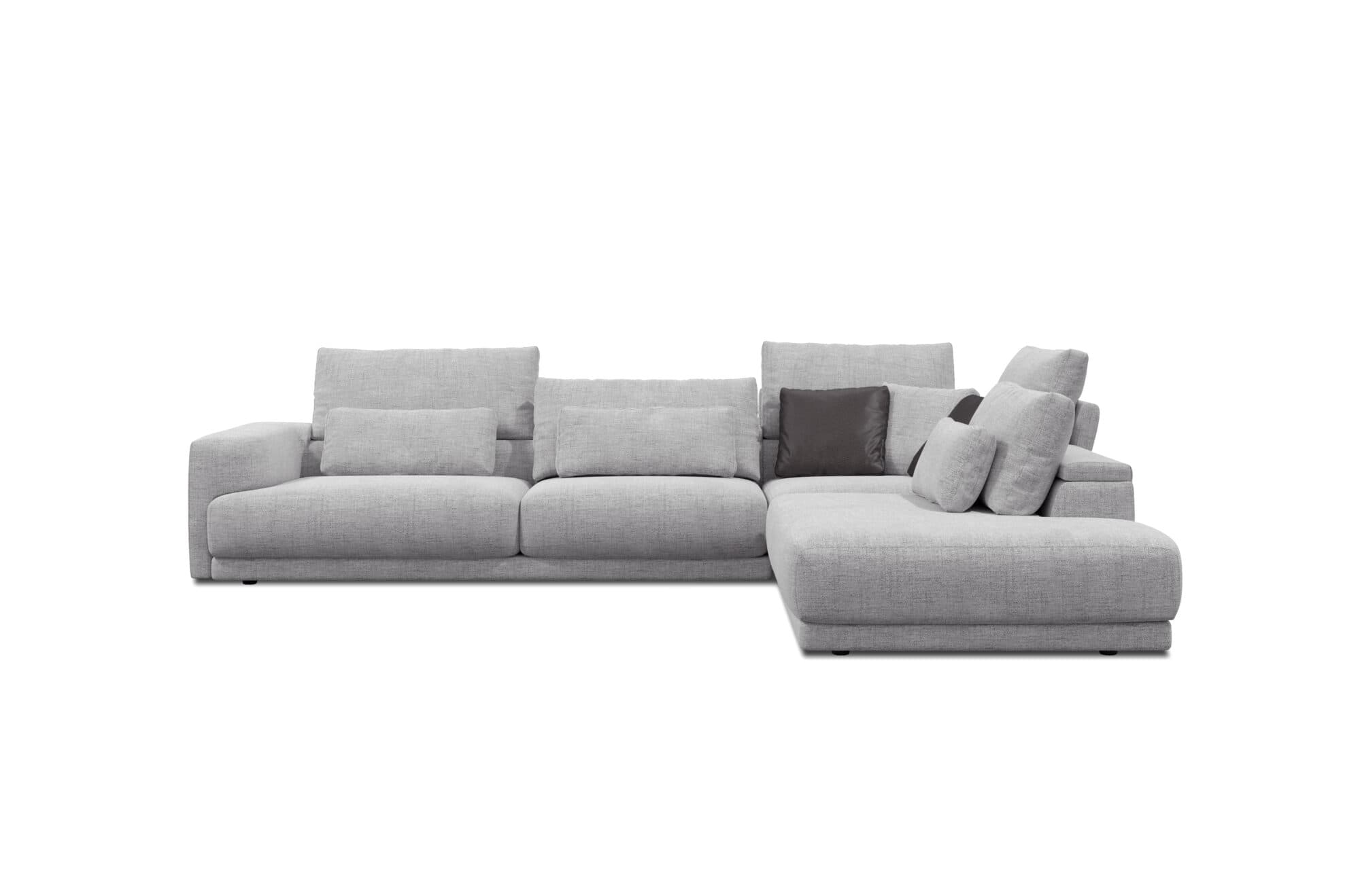 A modern sectional sofa with a chaise lounge extension. The sofa is upholstered in a light grey textured fabric and features multiple loose back cushions and accent pillows, including one darker grey pillow. The design is contemporary with clean lines and low-profile legs. — 3D model