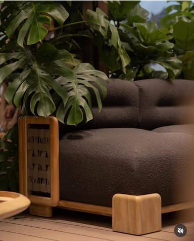 A modern two-seater sofa featuring a robust wooden frame and dark brown textured upholstery. The design incorporates distinctive woven detailing on the armrest sides and prominent block-style wooden legs. — 3D model