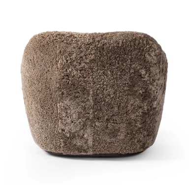 A plush, upholstered armchair with a rounded, organic silhouette. The piece features a thick, textured covering resembling sheepskin or a similar natural fiber, providing a soft and inviting appearance. The armrests are integrated into the body of the chair, flowing seamlessly into the back and seat. The base is low and broad, contributing to its sturdy and comfortable design. — 3D model