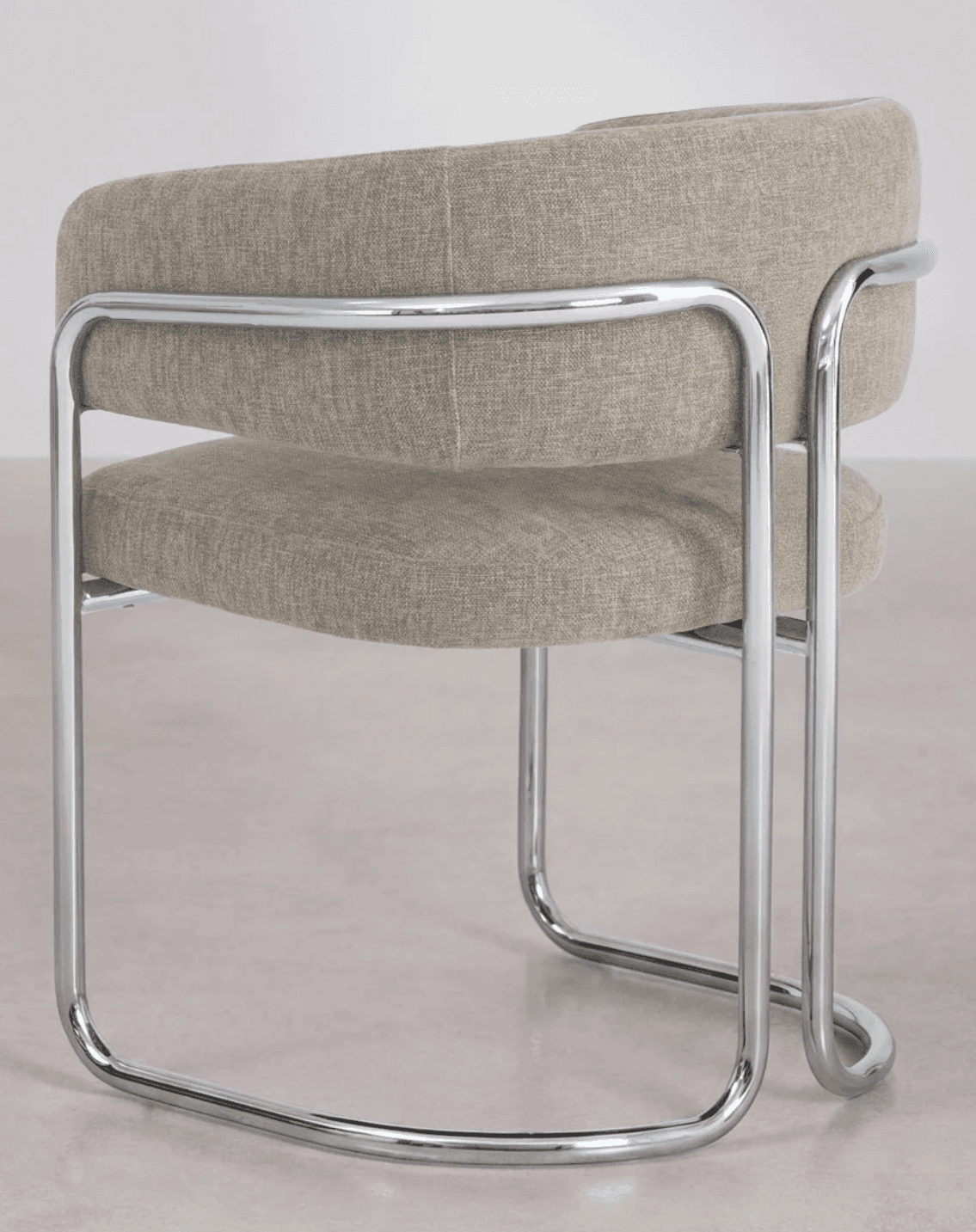 A modern armchair with a tubular chrome frame and upholstered seat and back. The frame consists of bent chrome tubes forming the legs, armrests, and supporting structure for the upholstery. The seat and backrest are upholstered in a textured, neutral-toned fabric. — 3D model