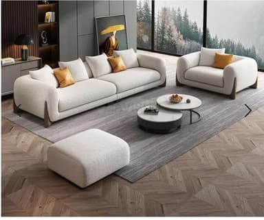 A contemporary modular sofa composed of two sections, upholstered in a cream/off-white bouclé fabric, featuring rounded track arms and distinctive dark wood supports. — 3D model