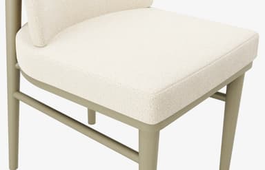 An armless dining chair featuring a fully upholstered seat and backrest in a textured, light cream boucle fabric. The frame is constructed from wood with a light sage green or greige finish, featuring gently tapered legs and stretchers for stability. A distinct cylindrical brass-toned metal accent is integrated into the upper part of one of the rear leg supports. — 3D model