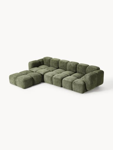 A modular sectional sofa composed of multiple cubic upholstered units. The sofa features a low profile and rounded edges on each module, creating a soft, organic aesthetic. It is upholstered in a textured, boucle-like fabric in a muted green hue. The arrangement suggests a configuration that includes a corner section and extended seating. — 3D model