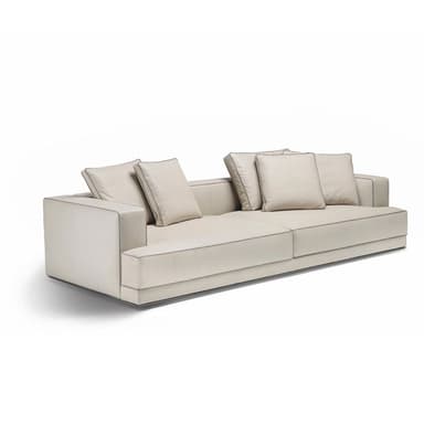A contemporary three-seater sofa characterized by its minimalist design, low profile, and neutral light beige upholstery with subtle contrast piping. It features integrated armrests and multiple loose back cushions. — 3D model