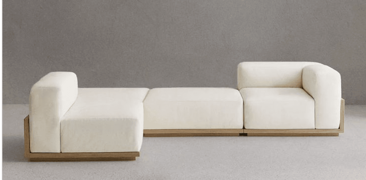 A contemporary modular sectional sofa comprised of three distinct sections: two end pieces with integrated armrests and one armless middle segment. Each module features a light-colored fabric upholstery and is set upon a recessed plinth base constructed from light-toned wood. — 3D model