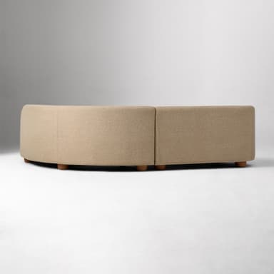 A modular, curved sectional sofa with a low profile and rounded edges. The sofa is upholstered in a textured beige fabric and supported by short, cylindrical wooden legs. — 3D model
