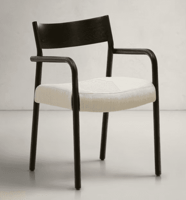 A modern armchair featuring a dark, matte-finished frame with a curved backrest and arms. The seat is upholstered in a light-colored, textured fabric. The legs are slender and cylindrical, matching the frame's finish. The design emphasizes clean lines and a minimalist aesthetic. — 3D model