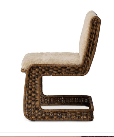 A chair with a rattan or wicker frame and upholstered seat and backrest with a sheepskin or faux sheepskin material. The frame has a woven texture. It features a low shelf or footrest integrated into the base, also constructed from woven material. — 3D model