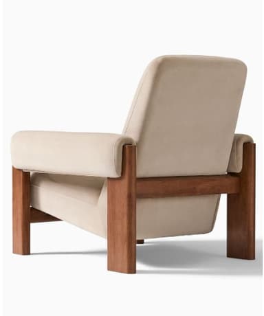 A modern armchair with a wooden frame and upholstered cushions. The armchair features a high backrest, wide armrests, and a supportive seat. The frame is constructed from solid wood, showcasing a natural finish. The upholstery is a soft, neutral-toned fabric, likely velvet or a similar plush material. — 3D model