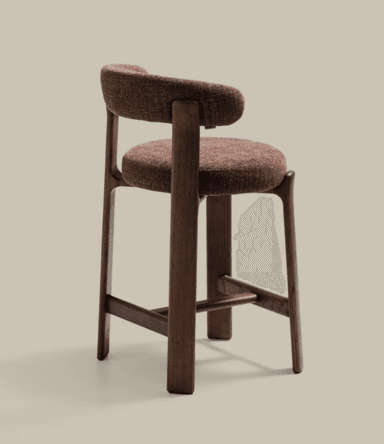 A modern counter stool featuring a dark wood frame and upholstered seat and backrest. The stool has a seat height of 56 cm and an overall height of 90 cm, suitable for counter-height surfaces. The backrest is rounded and upholstered in a textured, reddish-brown fabric, matching the circular seat cushion. The wooden frame consists of four sturdy, slightly tapered legs connected by stretchers on three sides, providing a stable structure and a footrest. — 3D model