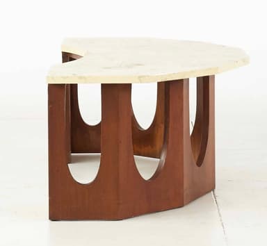 A coffee table with a light-colored, possibly marble or laminate, rectangular top with slightly beveled edges. The base consists of four vertical wooden elements, each with a large, semicircular cutout, arranged in a staggered pattern to form a visually open support structure. The wooden elements are dark brown and appear to be wood. — 3D model